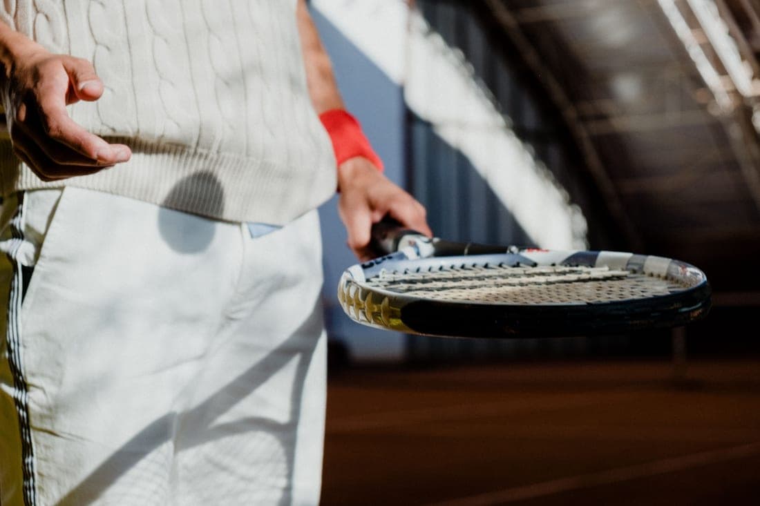 Player holding a tennis racket at the ready position on court