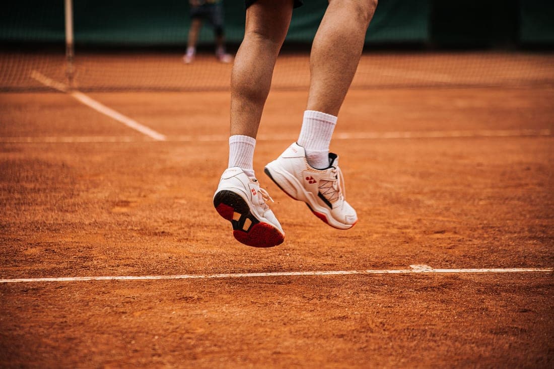 Court shoe outsole tread photographed against a hard court surface
