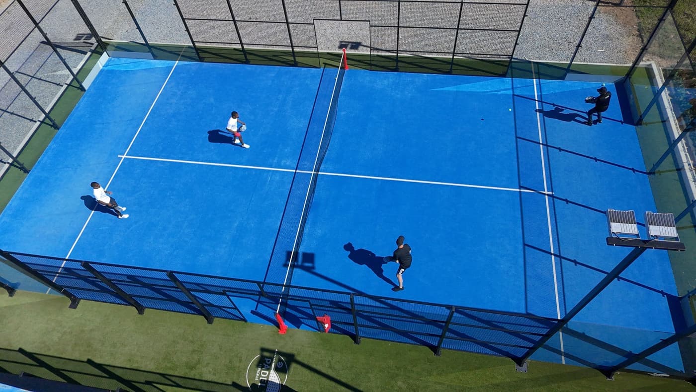 An outdoor paddle court enclosed by wire fencing