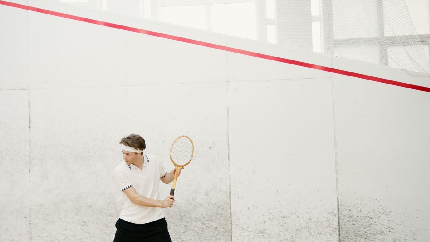 A player inside a glass-walled squash court