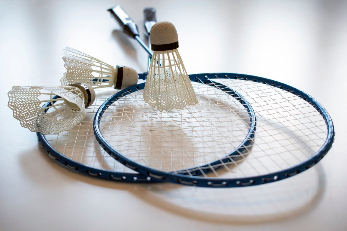 A badminton racket and shuttlecock beside a net