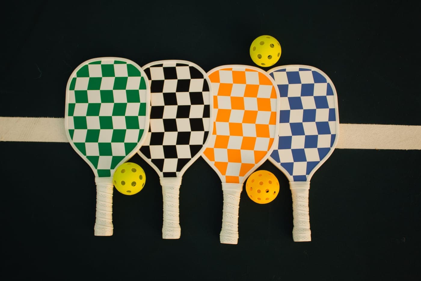 Pickleball paddles and perforated balls arranged on a court