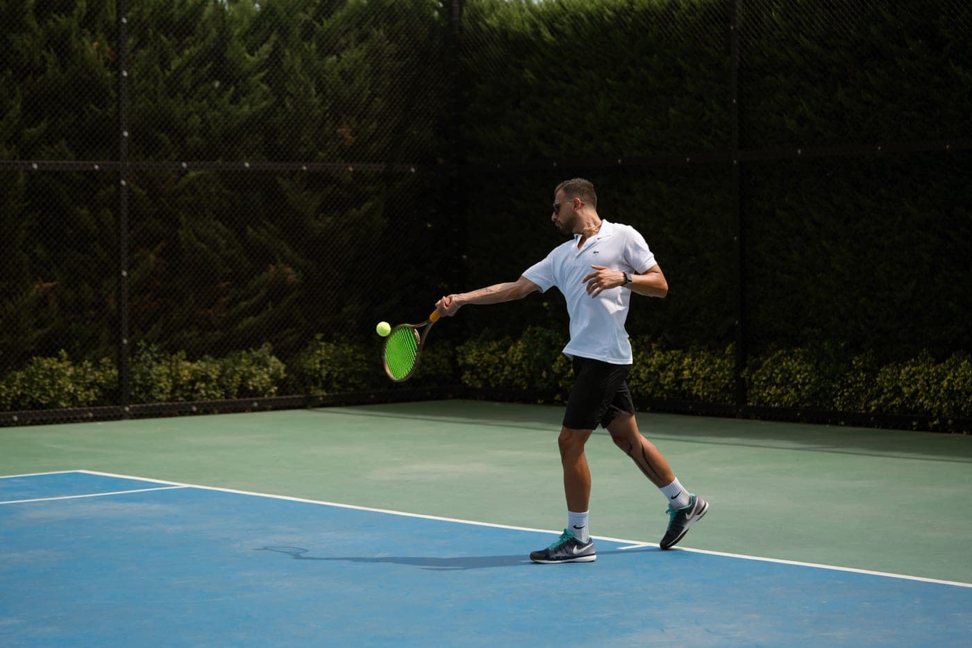 A racket mid-swing brushing up the back of a tennis ball