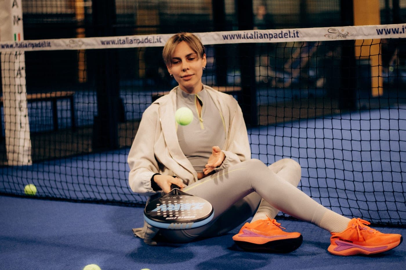A padel racket resting on a courtside bench