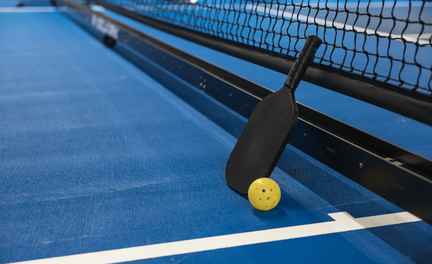 A pickleball paddle held in one hand on court