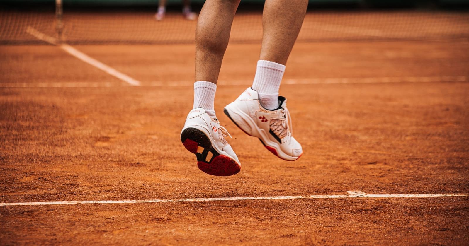 A player's court shoes seen from low to the ground as they push off mid-point